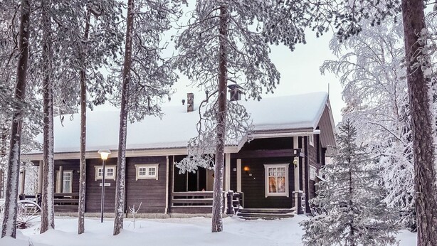 A wooden cabin with a porch, surrounded by snow-covered trees. - Sallanrinne b by Interhome (Salla)