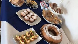 A table with various food items including pastries, fruits, and a cake.