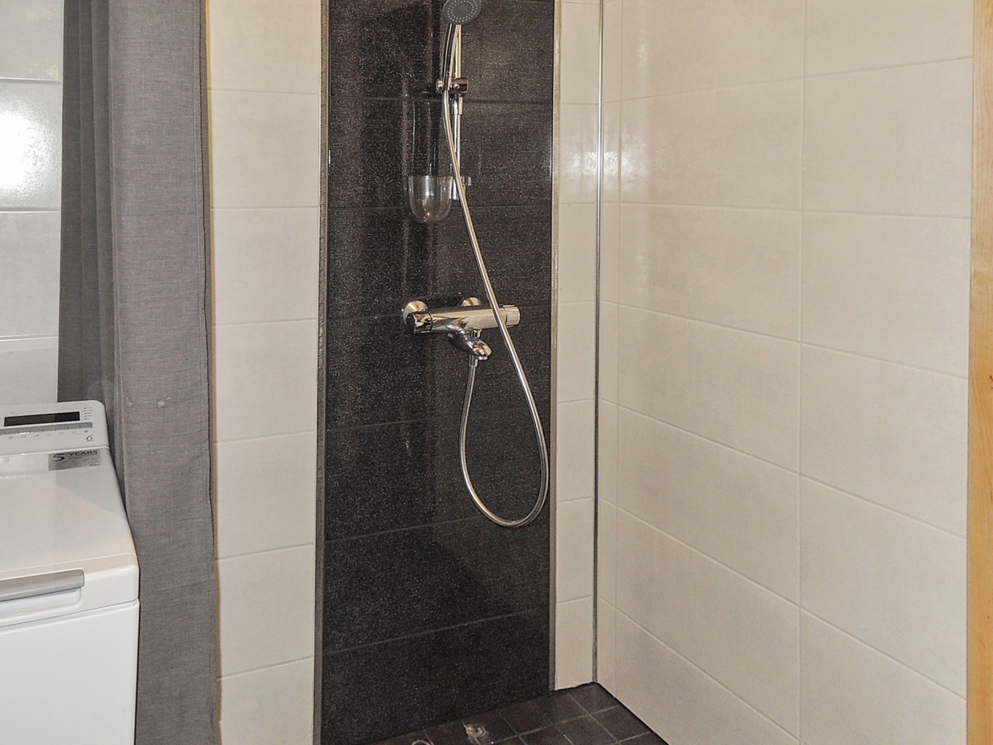 Eine Dusche mit Handbrause und Duschschlauch.