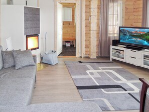 A modern living room with a sofa, a television, and a fireplace. - Nesterin helmi by Interhome (Eno)