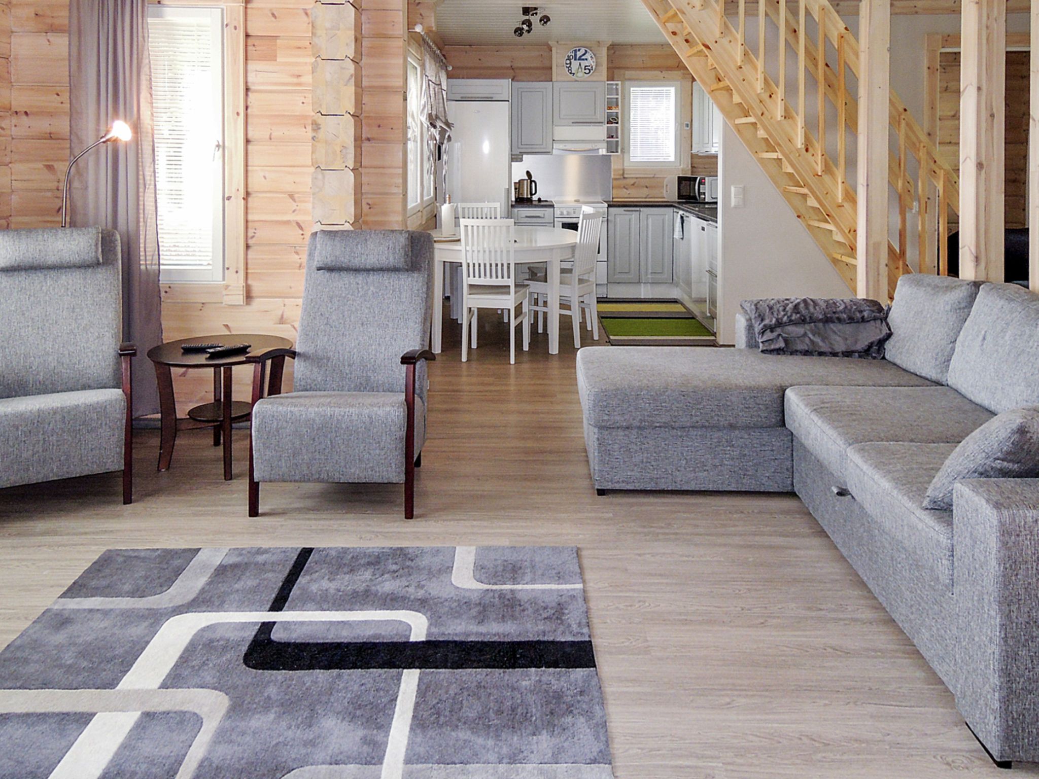 A modern living room with grey sofas, a coffee table, and a rug.