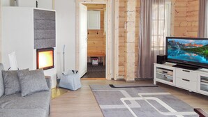 A modern living room with a grey sofa, a flat-screen TV, and a patterned rug. - Nesterin helmi by Interhome (Eno)