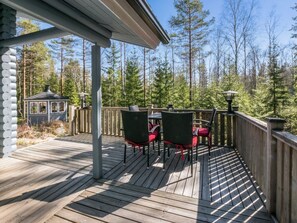 A wooden deck with outdoor furniture, a gazebo, and a forested backdrop. - Kiimalammi by Interhome (Forssa)
