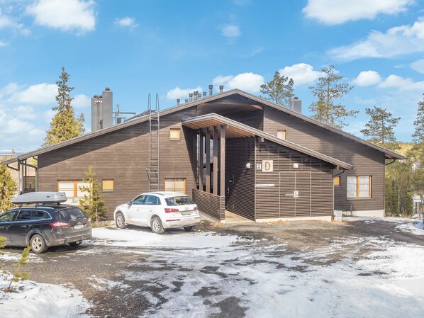 Ein modernes, zweistöckiges Gebäude mit Garage, überdachter Eingangspforte und Autounterstand.