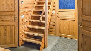 Una escalera de madera que lleva a una puerta con un ventanal azul con textura.