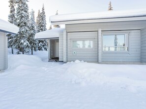 A snow-covered house with a garage door marked with the letter 'A'. - Rukan nietosrinne by Interhome (Kuusamo)