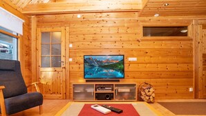 A cozy wooden cabin interior with a television, a sofa, and a coffee table.