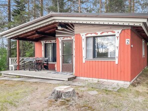 A small, single-story cabin with a porch, a table and chairs, and a number '2' on the side.