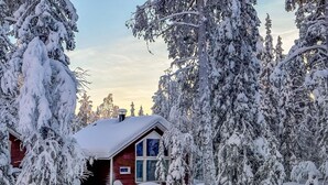 Une cabane entourée d’arbres couverts de neige.