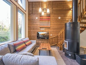A cozy living room with a sofa, a coffee table, and a fireplace. - Vacation home Kuura by Interhome (Ylläsjärvi)
