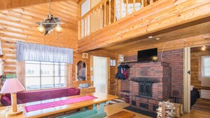 A cozy cabin interior with a wooden interior, a fireplace, a bench, and a table. - Eteläranta by Interhome (Joutsa)