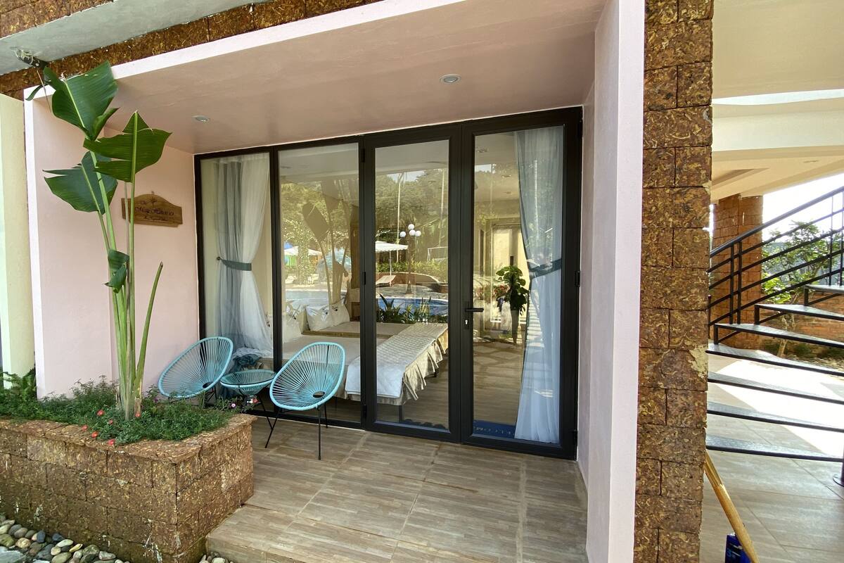 A modern outdoor seating area with a glass door leading to a poolside.