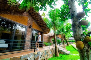 A hotel with a brick exterior, large windows, and a stone pathway leading to the entrance. - May Tropicall Villas (Hanoi)