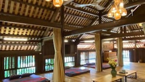 A spacious room with a high wooden ceiling, large windows, and hanging spherical light fixtures. - May Tropicall Villas (Hanoi)