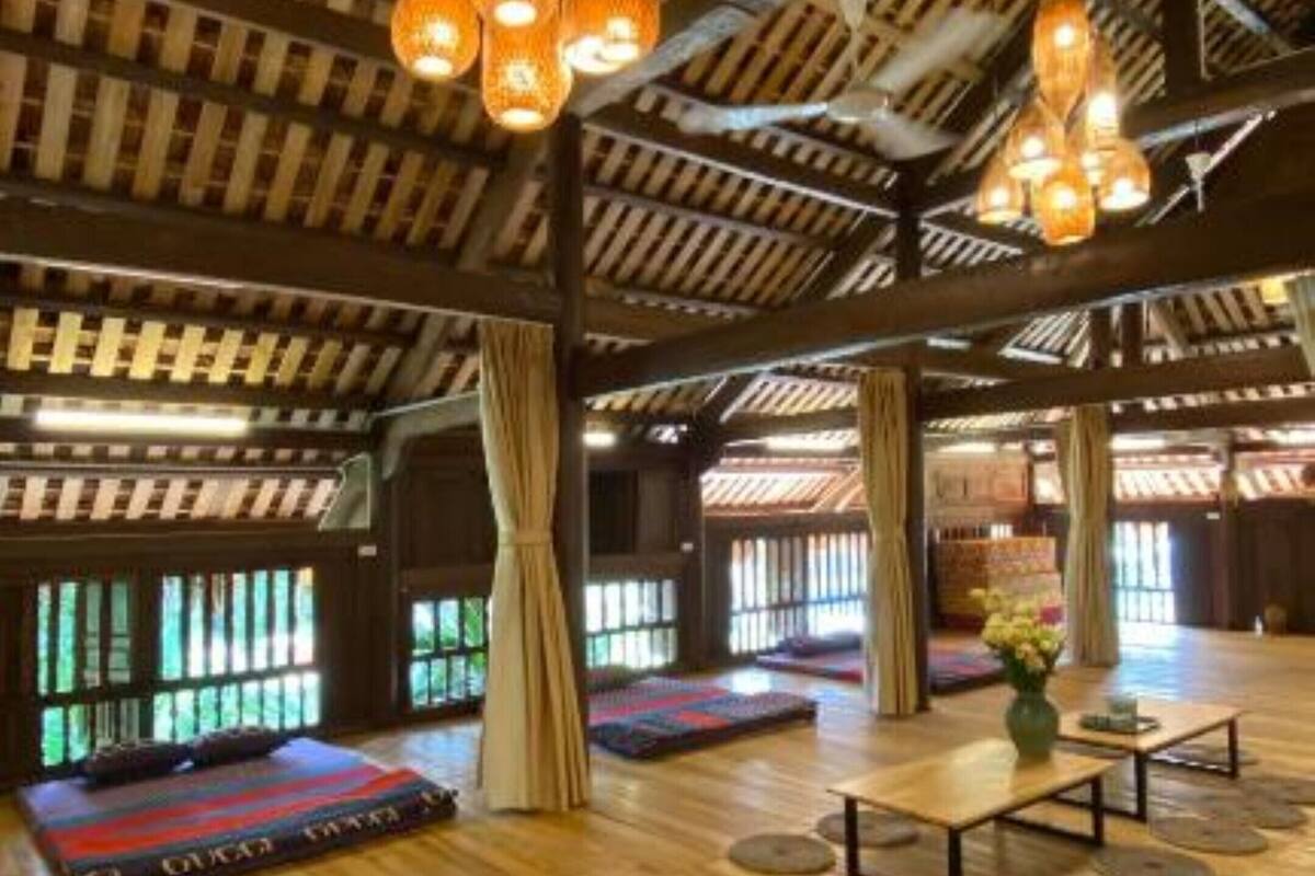 A spacious room with a high wooden ceiling, large windows, and hanging spherical light fixtures.