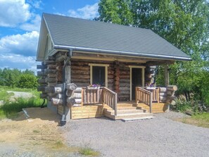 A log cabin with a porch and two doors, surrounded by trees. - Keloanttila by Interhome (Pyhäjoki)