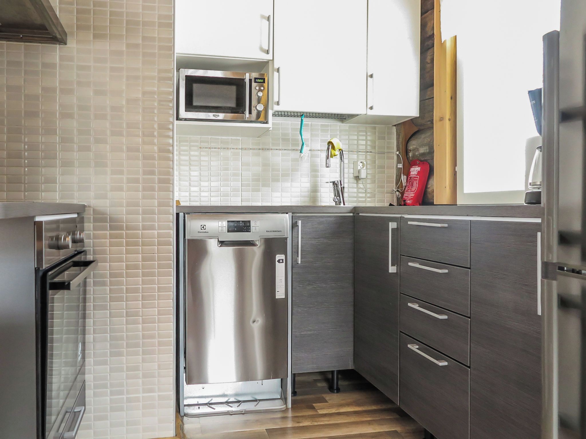 A compact kitchen with a built-in microwave, dishwasher, and oven.