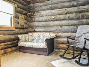 A log cabin interior with a sofa, a rocking chair, and a window with blinds. - Keloanttila by Interhome (Pyhäjoki)