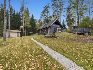 A cabin with a wooden deck, surrounded by trees and a clear sky. - Mykkylä by Interhome (Mikkeli)