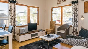 A compact living space with a TV, sofa, and dining area.