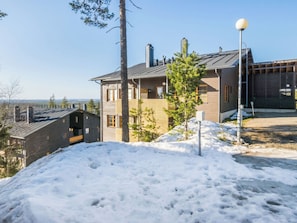 Un bâtiment à deux étages, doté d’une façade en bois, d’un balcon et offrant une vue sur le paysage environnant.
