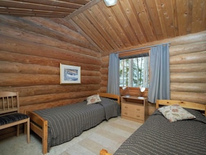 A log cabin bedroom with two beds, a desk, and a chair. - Tatunmökki by Interhome (Mikkeli)
