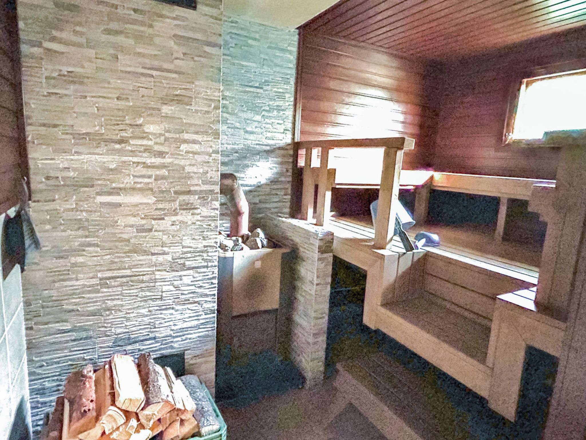 A room with bunk beds, a stone wall, and a small table with items on it.