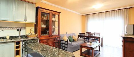 A compact living space with a kitchen, dining area, and seating.