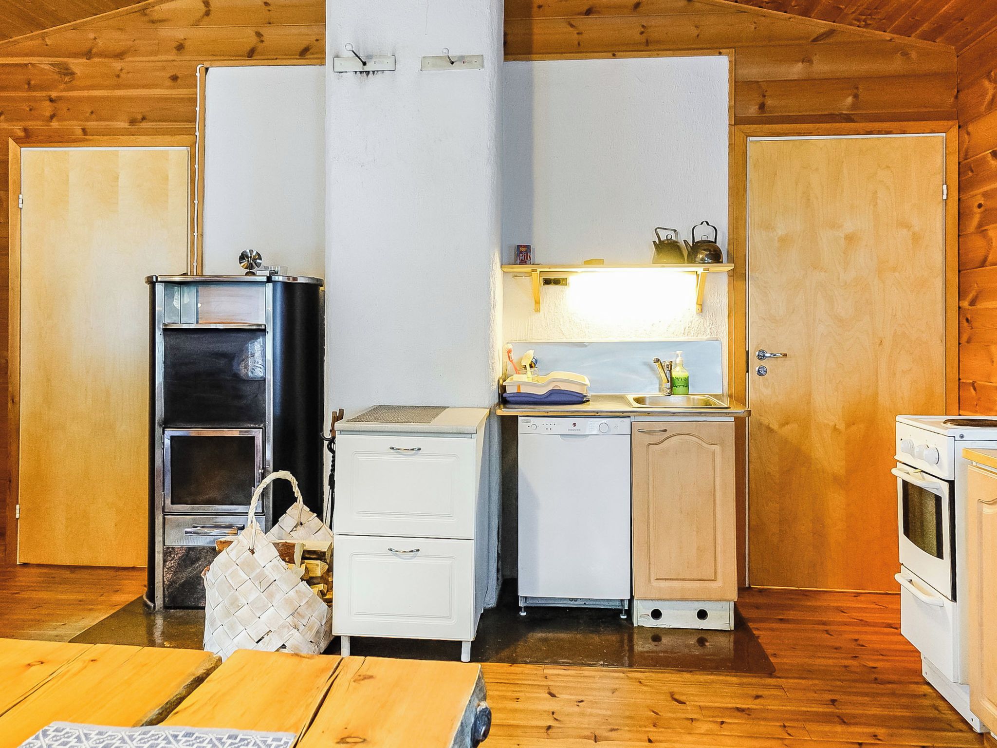 A compact kitchen with a refrigerator, a stove, a sink, and a small cabinet.