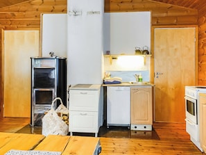 A compact kitchen with a refrigerator, a stove, a sink, and a small cabinet. - Hoviranta by Interhome (Inari)