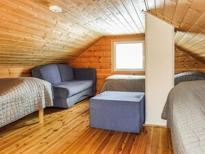 A cozy attic bedroom with wooden walls, a window, and a loft bed. - Hoviranta by Interhome (Inari)