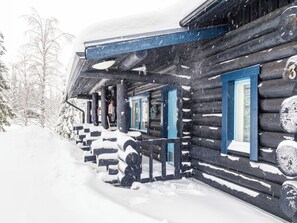 A log cabin with a snow-covered porch and a number '3' on the door.