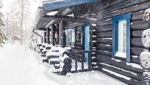 A log cabin with a snow-covered porch and a number '3' on the door.