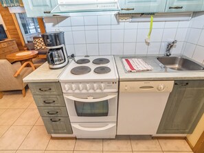 A compact kitchen with a stove, oven, dishwasher, and a coffee maker. - Villa lakka by Interhome (Kuusamo)