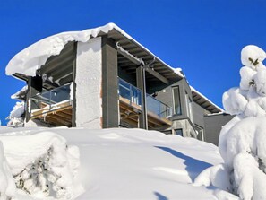En moderne bygning med balkon og sneklædte omgivelser.