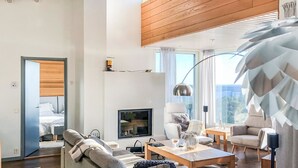 Een moderne woonkamer met een bank, stoelen, een salontafel en een televisie.