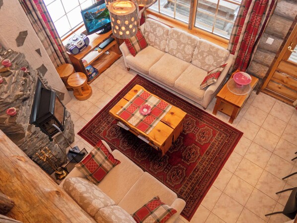 A cozy living room with a sofa, coffee table, and a fireplace.