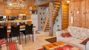 Ein gemütliches Blockhaus-Interieur mit Essbereich, Küche und Treppe.