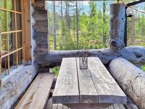 A rustic wooden cabin with a bench and a table, surrounded by natural forest scenery. - Kelovalta 7b by Interhome (Kuusamo)