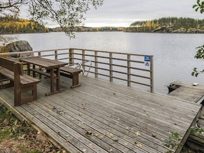 A wooden deck with benches and a railing overlooking a calm lake. - Etelärinne by Interhome (Punkaharju)