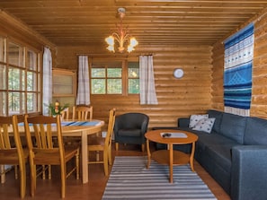 A log cabin interior with a dining area, a sofa, and a small table. - Etelärinne by Interhome (Punkaharju)