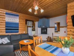 A cozy cabin interior with a living room, dining area, and kitchenette.