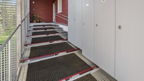 Un escalier avec des marches en métal menant à une série de portes blanches, chacune portant un numéro.
