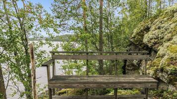 A wooden bench overlooking a lake, surrounded by trees and rocky terrain.