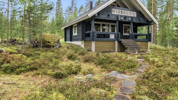 A cabin with a stone pathway leading to it, surrounded by a forest.