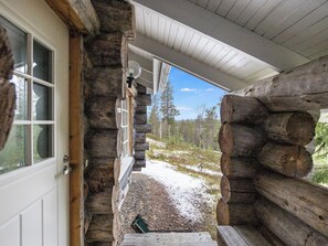 En hytte med veranda, dør og vindue.