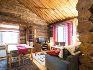 A log cabin interior with a dining area, a sofa, a television, and a fireplace. - Lomaylläs d58 /palovaarankaarre 11b by Interhome (Ylläsjärvi)