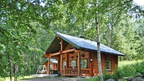 A wooden cabin with a porch, surrounded by trees and a dirt path. - Rantatupa by Interhome (Ruovesi)