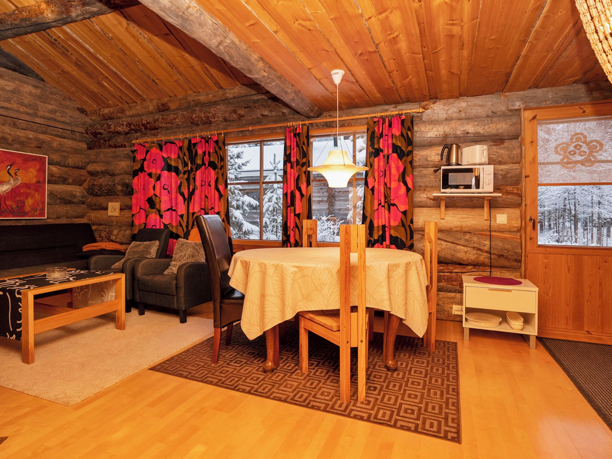 A cozy log cabin interior with a dining area, a sofa, and a fireplace.