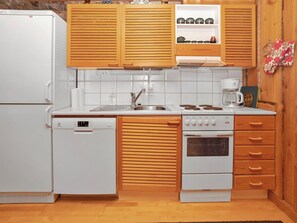 A modern kitchen with wooden cabinets, a built-in oven, a dishwasher, and a coffee maker.